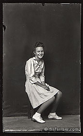 Young Woman Smiling, Seated on Stool